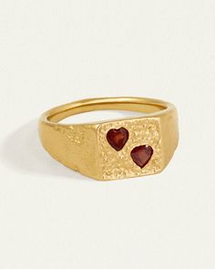 The Venus Signet Ring is a bold statement of love's enduring strength. 
 
Crafted from 18k gold vermeil, its substantial form is softened by twin heart-shaped garnets lovingly set into textured gold. This nostalgic design combines the timeless tradition of Roman signet rings with a modern, romantic twist. 
 
When worn, it becomes a personal talisman, a powerful reminder of love's presence and the cherished commitments we hold dear. Heirloom Gold Ruby Ring For Valentine's Day, Fine Jewelry Gold Ruby Heart Ring, Signet Ring Gold, V Ring, Nostalgic Design, Seal Ring, Roman Goddess, Rock Jewelry, Gold Signet Ring