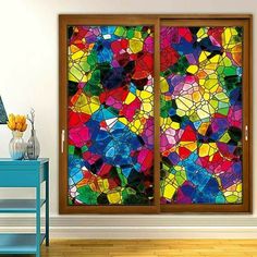 a colorful stained glass window in a room with wooden flooring and blue side table