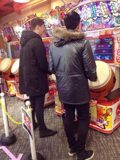 two men standing in front of an arcade machine