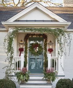 the front door is decorated with greenery and wreaths