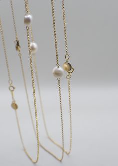 Named after a spin on the lovely Marigold flower, this pearl necklace symbolizes divinity as well as the beauty of patience on your journey to growth/alignment. She adds a simple-yet-striking touch of elegance and grace, and is very versatile for styling! Made with high-quality 14K Gold Filled materials, the Merrigold necklace is both water/tarnish-resistant, so you can swim all day and night under the sun and moon. NECKLACE DETAILS: 14K Gold-Filled Chain Freshwater Pearl Unique 14K Gold-Filled GEO Tag MEASUREMENTS: 16.5" Necklace Note: Many GEOLOVERS pieces are uniquely handmade. Each piece may vary slightly as a result, including the shapes of natural pearls. Yellow Gold Charm Necklace With Pearl Drop, Feminine Gold Jewelry With Pearl Charm, Gold Akoya Pearl Necklace With Round Pendant, Elegant Gold Plated Long Charm Necklaces, Gold Long Single Strand Necklace, Elegant Gold Long Charm Necklace, Elegant Long Pendant Necklace, Classic Gold Pearl Necklaces, Spiritual Single Strand Pearl Necklaces