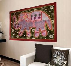 an elephant tapestry hanging on the wall above a couch