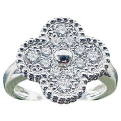 a silver ring with white stones on it's center and an intricate design in the middle