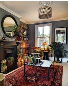 a living room filled with furniture and a fire place next to a large mirror on the wall