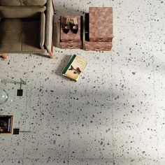 an overhead view of a living room with couches, coffee table and books on the floor