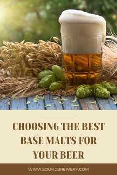 a glass of beer sitting on top of a wooden table next to wheat and hops