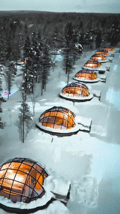 an aerial view of several glass iglas in the middle of snow covered ground