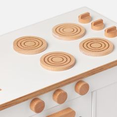 a white stove top with wooden knobs on it