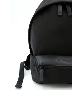 a black backpack sitting on top of a white floor