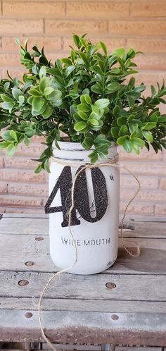 a plant in a mason jar with the number forty on it, sitting on a wooden table