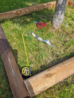 some tools are laying on the grass near a tree