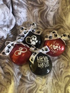 four glass ornaments with black and white designs on them, one has a dog's paw print