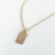 This mini dog tag necklace is perfect for every day wear. This engraved necklace features a small dog tag shaped rectangle in 14k gold fill or sterling silver engraved with a letter of your choice. The font comes in your choice of the classic style (in the photo) or script as shown on the photos. Your new letter or initial necklace will arrive in a complimentary gift box. Please be sure to indicate if you want the script font, otherwise your necklace will be engraved with the classic style. Othe Custom Engraved Necklace, Mini Dog, Diamond Birthstone, Mini Dogs, Alexandria Va, Engraved Necklace, Necklaces For Women, Letter Necklace, Script Font