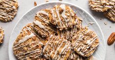 a white plate topped with cookies covered in frosting and pecans on top of a table