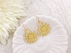 "These are lovely and beautiful shinning golden plated sunflower earrings. They hang underneath golden plated French ear wires. The earrings measure about 37mm (1.5 inches) long from the top of the earwires to the bottom of the flower. A wonderful idea for gift giving or as a little treat for yourself. Your item will arrive in gift wrap and ready to gift. Measurements and details: Total length: approximately37mm (1.5\") Flower: 24mm across Ear wire: golden plated French ear wires PLEASE NOTE: Al Gold Birth Flower Shaped Earrings, Gold Flower-shaped Earrings For Mother's Day, Mother's Day Gold Flower-shaped Earrings, Gold Flower Earrings For Wedding With Birth Flower, Gold Flower Earrings With Birth Flower For Wedding, Gold Birth Flower Earrings For Wedding, Elegant Gold Flower Earrings With Sunflower Design, Gold Birth Flower Earrings, Gold Birth Flower Round Earrings