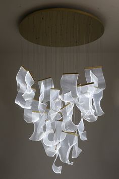 a chandelier made out of white organine ribbons hanging from the ceiling