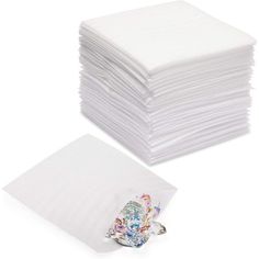 a stack of white napkins sitting next to each other on top of a table