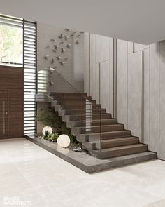 a staircase in the middle of a room next to a wall with birds on it