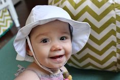 a smiling baby wearing a white hat