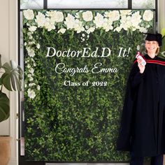 a man standing in front of a green wall holding a graduation cap and gown with the words doctor edd it congratulations emma class of 2012