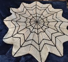 a white crocheted spider web on a blue blanket