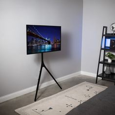 a flat screen tv sitting on top of a wooden stand next to a book shelf