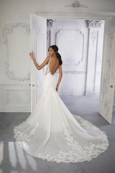 a woman in a white wedding dress is posing for the camera with her hand on her hip