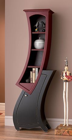 a book shelf with books on it next to a vase and other items in the corner