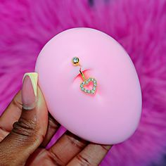 a person holding a pink ball with a diamond ring on it's end and a fake pearl in the middle