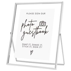 a sign that says, please sign our photo guestbook and share it with stick - it