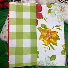 three pieces of fabric sitting on top of a green cloth covered table next to a white teddy bear