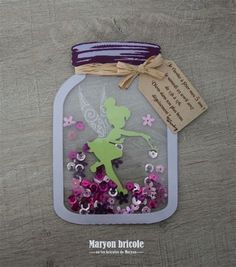 a glass jar filled with purple and green confetti next to a tag that says,