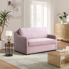 a living room with a pink couch and coffee table in it's center area