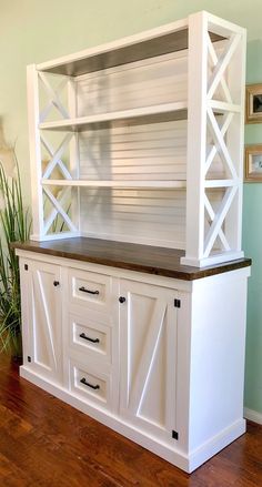 a white entertainment center with sliding doors and drawers