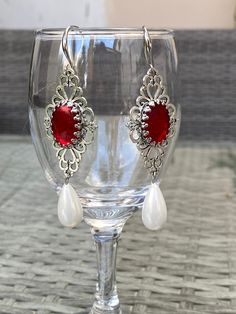 Gothic dangle earrings with tear drop pearls and red cabochon. Historical pearl drop earrings Materials used are Glass pearls, zinc alloy Centre cabochon is glass Measures as follows from top to bottom drop pearl 63mm including top pearl, excluding hooks Wrapped in gift box RETURNS EXCHANGES REFUNDS Returns, exchanges or refunds are accepted for may handmade jewellery pieces only from EU countries. Customer is responsible to pay for the return. Refund is for the cost of the product. For countrie Ornate Red Earrings For Party, Ornate Red Teardrop Jewelry, Ornate Red Cabochon Jewelry, Ornate Red Drop Earrings, Cabochon Pearl Drop Earrings For Gift, Red Elegant Nickel-free Teardrop Earrings, Victorian Teardrop Metal Jewelry, Ornate Metal Jewelry With Pearl Drop, Red Pearl Drop Earrings For Party