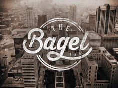 the bagel bar logo on top of a cityscape