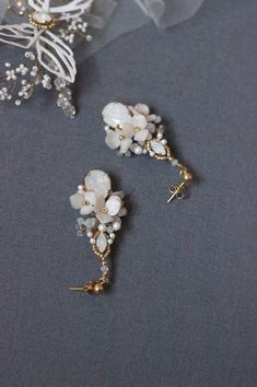 Wedding dangle floral earrings, Swarovski crystal and pearl rhinestone bridal earrings in white and gold color, Flower jewelry for bride A delicate Swarovski crystal and pearl earrings for wedding created of silver color Japanese Toho beads, Swarovski crystals and pearls, wired with silver color wire. 925 sterling silver earring studs. Measures about 0,98 by 1.97 inches /2.5 by 5 cm (at its widest part ). ♥100% handmade. ♥This item will be ready to ship within 5 business days (shipping time not White Crystal Earrings With Pearl Drop, White Crystal Pearl Drop Earrings, White Pearl Drop Earrings With Crystal, White Pearl Drop Crystal Earrings, Elegant White Crystal Flower Earrings, White Pearl Cluster Earrings For Wedding, White Crystal Pearl Drop Chandelier Earrings, Pearl White Crystal Bridal Earrings For Wedding, Delicate White Crystal Earrings