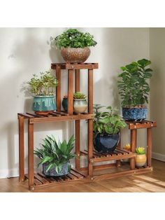 three tiered wooden plant stand with potted plants