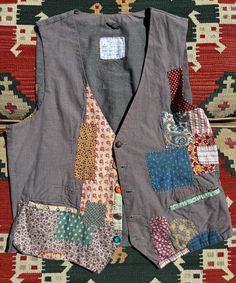 an old vest with patchwork on it sitting on a rug