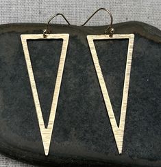 "Modern, edgy and stylish! Elongated triangle dangle earrings are eye catching and versatile. Dress them up or down. They would complete any look. The earrings measure 1 7/8\" long 3/4\" wide, They hang from simple gold ear wire hooks. Overall drop length is 2\". Made from plated gold. I have this same earring style also available in silver. Here is a direct linkhttps://www.etsy.com/listing/1461787368/ Thanks for stopping by! Please take a moment and visit the rest of my Etsy shop. I have many m Trendy Gold Triangle Earrings, Nickel Free Triangle Metal Earrings, Nickel-free Metal Triangle Earrings, Modern Triangle Metal Earrings, Modern Nickel-free Triangle Earrings, Modern Triangle Earrings For Party, Modern Triangle Party Earrings, Modern Gold Earrings, Statement Earrings Gold