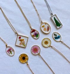 six different necklaces with flowers and plants on them