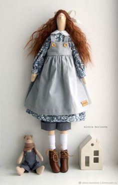 a doll with long red hair standing next to a teddy bear on a white shelf