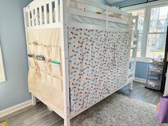 a baby crib in the corner of a room with blue walls and wooden floors