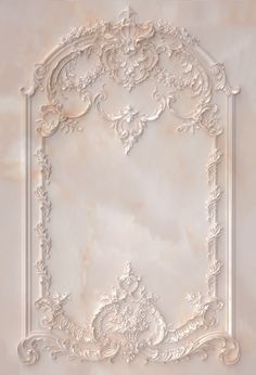 an ornate white frame on a marble wall