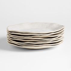 five white plates stacked on top of each other in front of a white background,