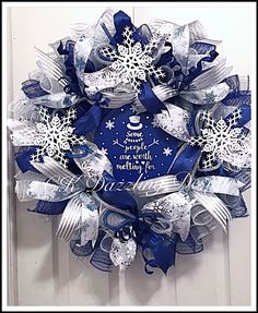 a blue and white christmas wreath with snowflakes on the front door for someone's special holiday