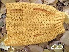 a yellow knitted hat laying on top of leaves