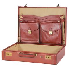 an open red suitcase with two compartments on the bottom and one in the middle, sitting against a white background