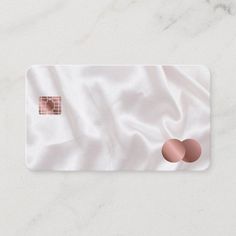 a white card with a pink circle on the front and two brown circles on the back