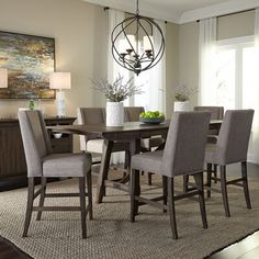 a dining room table and chairs with a rug on the floor in front of it